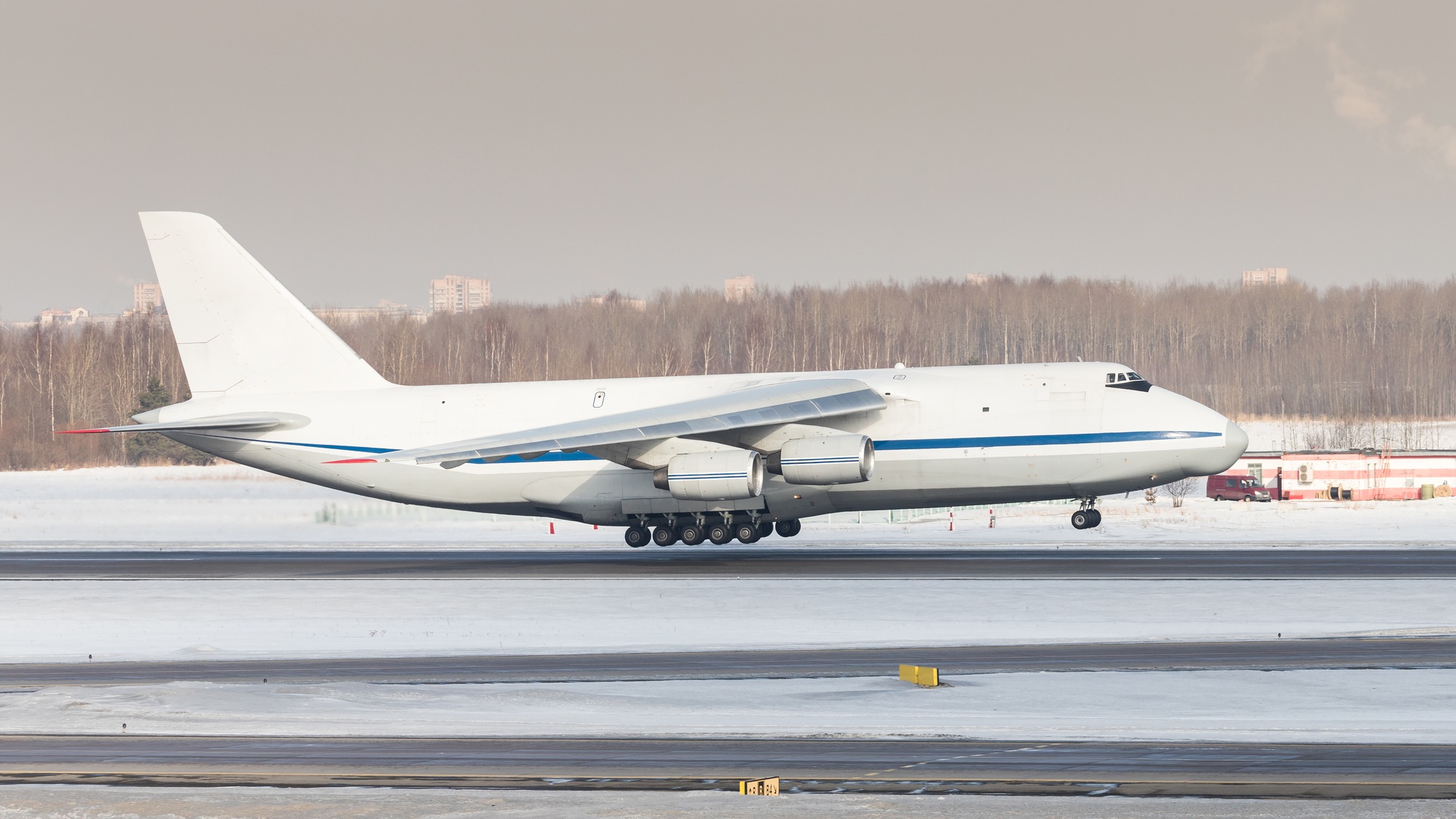 Huge white wide-body cargo airplane take off at sunny winter day. Transportation, cargo, aviation.
